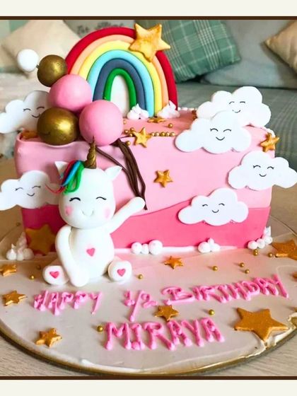 A cheerful half-birthday cake with a cute unicorn, a bright rainbow, and happy little clouds, celebrating six months of joy.