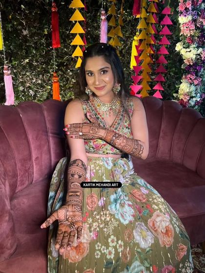 A beautiful bride in a floral lehenga, her mehandi design perfectly complementing her outfit.