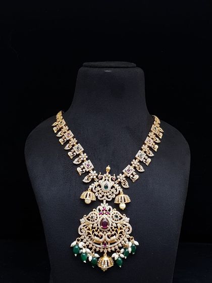 A grand necklace with a large pendant featuring AD stones, green beads, and pearls. This is a statement piece that will surely turn heads at any event.