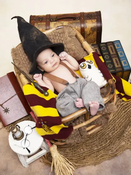 For fans of fantasy, I offer fully styled themes like this Harry Potter newborn shoot. The setup includes a sorting hat, magic wand, house scarf, and other iconic props to create a magical first portrait.