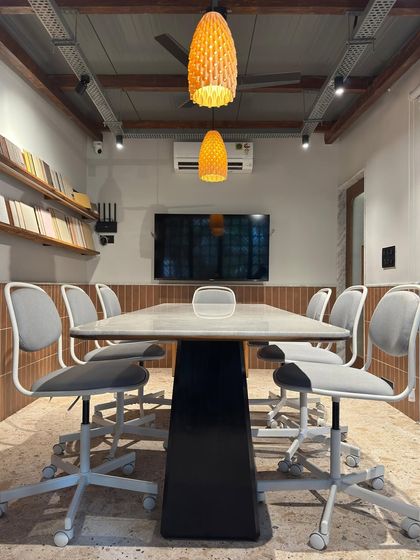 The main meeting room in our studio extension, featuring a large central table, ergonomic chairs, and shelves for material samples. This space is designed for collaborative brainstorming sessions and client presentations.