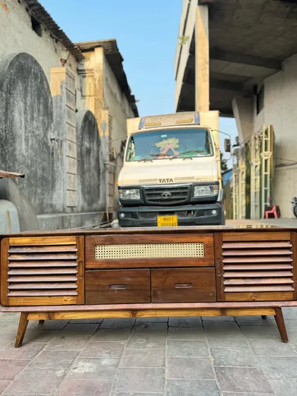 This media console combines multiple textures, including slatted doors, drawers, and a central cane-panelled section. It's a highly functional piece with a strong mid-century aesthetic.