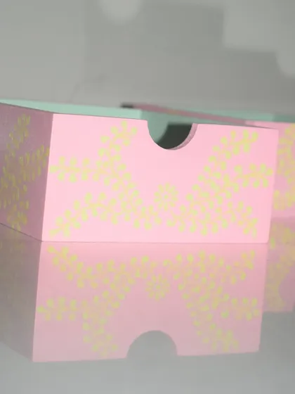 Another angle of the pastel pink organizers, showing how they can be stacked or arranged to suit your needs. The hand-painted details make each box unique.