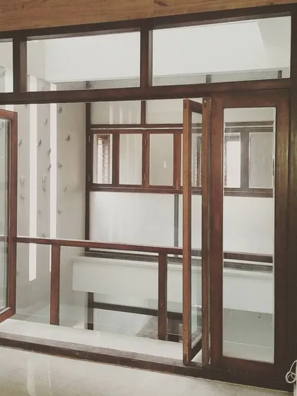 This internal balcony features sliding and folding wooden doors that can open up completely, connecting the living room to a guest room across the lightwell.