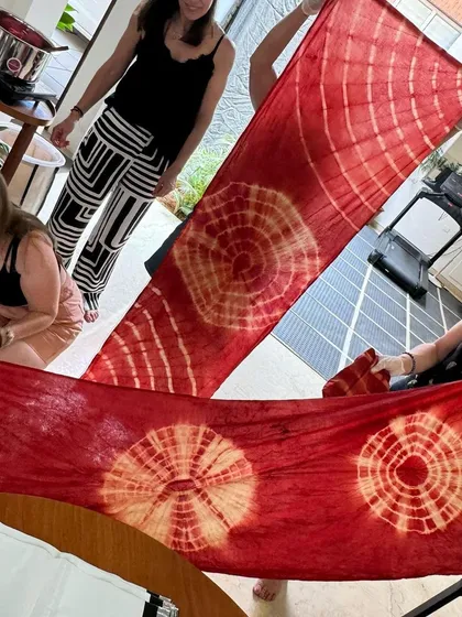 The stunning results of a tie-dye workshop. These long stoles, with their vibrant red and white patterns, show the beautiful effects that can be achieved with natural dyes.