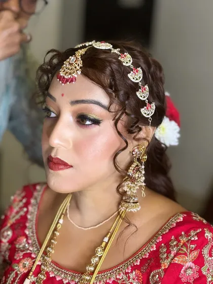 This shot highlights the dramatic eye makeup and bold red lip. It's a powerful and confident bridal look, perfect for the modern bride.