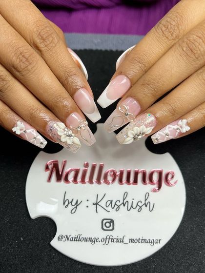 An incredibly detailed set with a sheer pink base, white French tips, and an abundance of 3D flowers and bows.