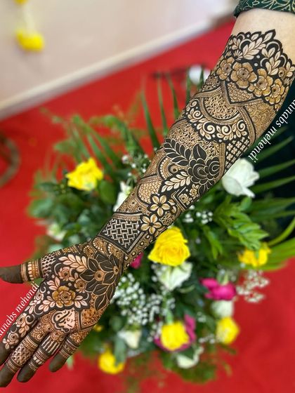 Full arm bridal henna for Nazreen, featuring a mix of bold floral patterns and intricate geometric fillers.
