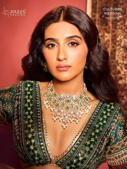 A magazine feature of Nimrit Ahluwalia, showcasing the intricate details of the emerald and polki necklace that defines bridal luxury.
