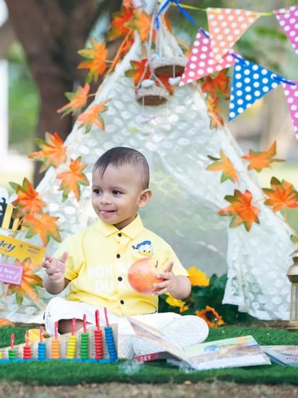 A happy smile from inside our autumn-themed tent setup. I use colorful banners, leaves, and toys to create an engaging environment for your child's photoshoot.