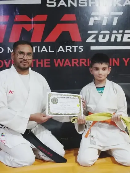 This young boy is awarded his orange and yellow belts, showing his rapid progress and dedication.