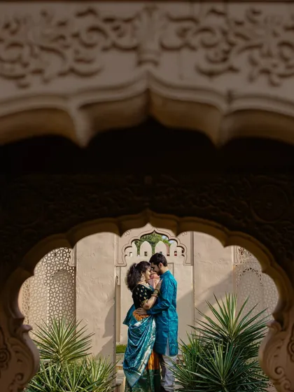 A beautifully framed silhouette of the couple within an ornate archway. This artistic shot uses the architecture to create a sense of intimacy and timeless romance.