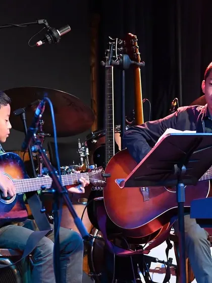 A close-up of our guitar duet, David and Samuel, concentrating on their piece. We encourage duo and small group performances to build musical communication skills.