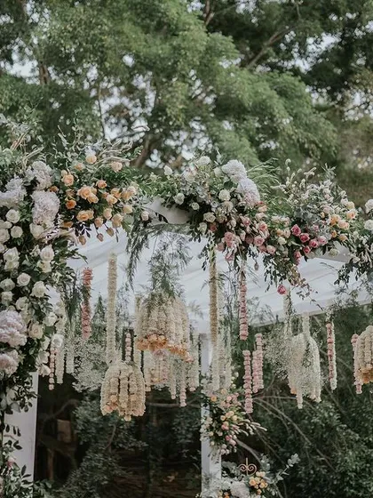A close-up of the lush floral archway, featuring a mix of pastel roses and greenery, creating a romantic entrance.
