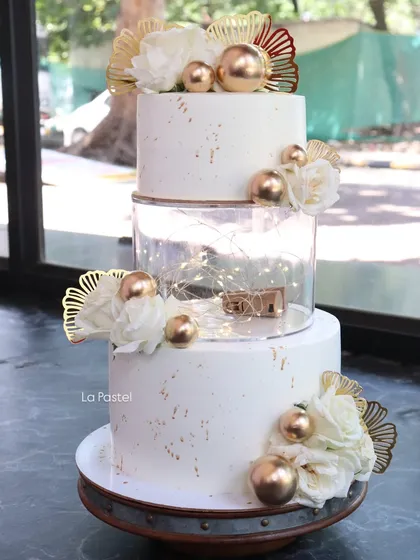 I love adding a modern twist to classic designs. This three-tier cake features a clear acrylic spacer filled with twinkling fairy lights, giving it a magical, floating effect perfect for an evening reception.