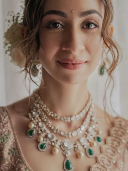 A soft and dreamy look for a bride who loves understated elegance. Her makeup features a gentle, luminous glow with fresh flowers in her hair, proving that minimal can be incredibly impactful.