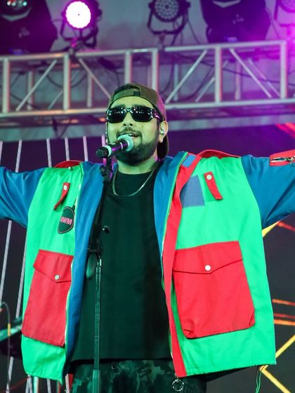 Shashwat Singh with his arms open to the audience, creating an inclusive and exciting concert atmosphere at MIT Bengaluru.