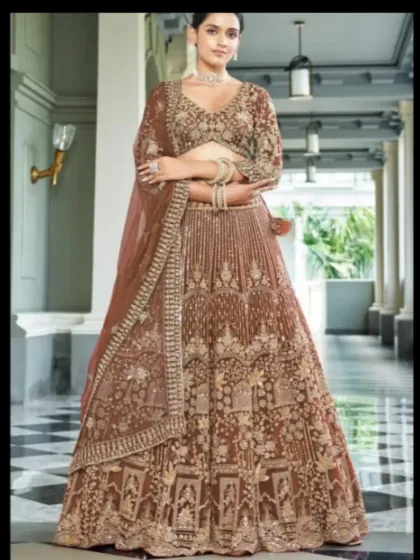 This rich brown lehenga is perfect for a winter wedding or reception. The velvet-like fabric is adorned with heavy gold embroidery, giving it a warm and opulent feel.