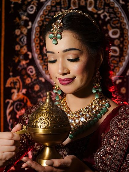 This shot captures the serene and traditional vibe of the bridal look. The makeup is kept soft and glowing to complement the rich colors and textures of the outfit and the antique-style jewelry.