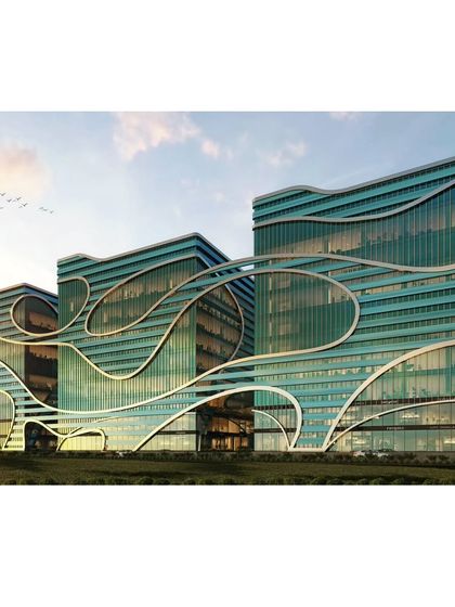 This render shows the three interconnected commercial towers at sunset. The flowing, organic lines of the façade are highlighted, demonstrating a design that is both modern and inspired by nature.