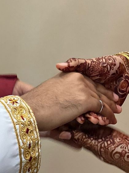 Being a part of a couple's special day is a privilege. This photo captures a beautiful moment from a wedding, where the groom is wearing a saya kurta I crafted. The intricate gold handwork on the cuff is visible as he holds his bride's hand.