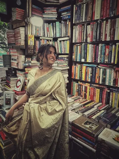 A candid moment inside the bookstore. The warm lighting and endless rows of books provided the perfect backdrop for this vintage saree look, creating an atmosphere of quiet nostalgia.