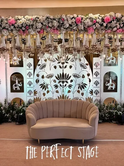 A full view of the "Perfect Stage," combining a dense floral canopy, hanging glass bells, and a beautiful illustrated backdrop for a truly unique design.