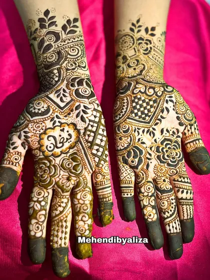 A beautiful party henna design with a mix of floral, geometric, and checkerboard patterns. The name of the client is beautifully written in the center.