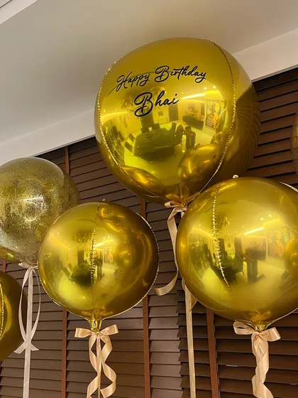 Personalization is key. A custom "Happy Birthday Bhai" message on a large gold balloon added a warm, personal touch to the sleek and modern birthday decor.