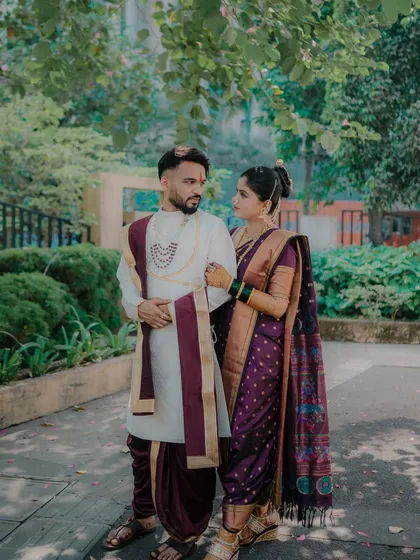 A beautifully composed shot of the couple standing together under the trees. The way they look at each other tells a story of love and companionship.