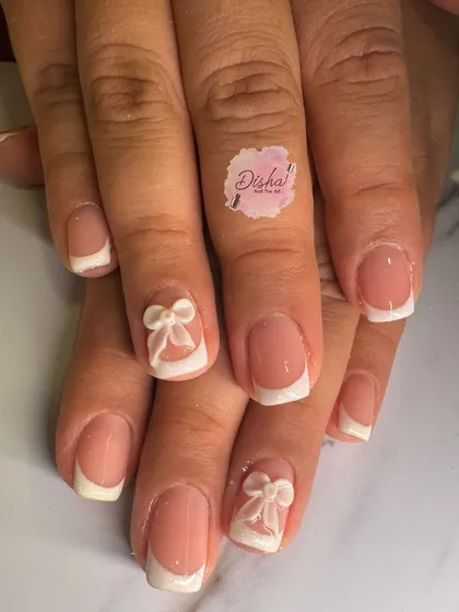 A classic French manicure with a cute twist. This design features simple white tips with adorable 3D white bows on the accent nails.