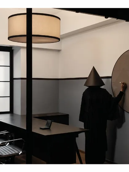 A large, round writing glass board intersects with the wooden boundary line in one of the cabins. This detail is in keeping with the simple, clean geometric forms used throughout the office design.