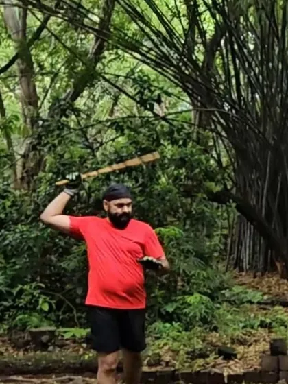 A student practices a striking motion with a stick. The focus and connection to nature during our outdoor sessions are a form of moving meditation.