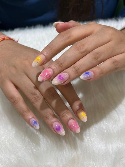 A dreamy and colorful aura nail set. Each nail has a different pastel aura gradient with a cute star or heart in the center, creating a soft and whimsical vibe.