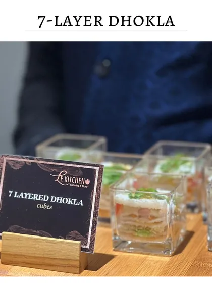 Another look at the 7-Layered Dhokla Cubes, with a menu card that clearly labels this innovative dish for guests at an event.