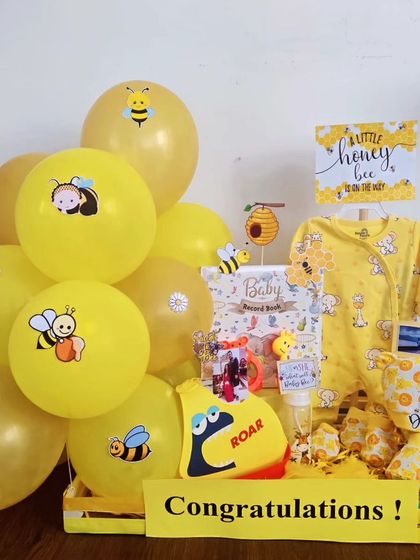 This 'Little Honey Bee' hamper is perfect for a gender-neutral gift. It includes a bee-themed onesie, a baby record book, and other cute, coordinated items.