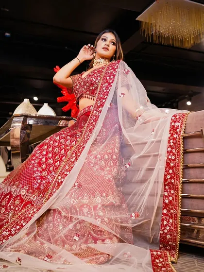 Another angle of the exquisite red bridal lehenga, emphasizing its luxurious feel and detailed craftsmanship. This image is perfect for e-commerce and catalog photography, showing the garment's beauty from all sides.