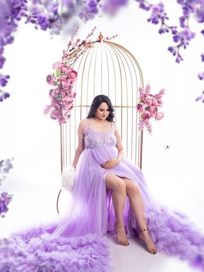 A whimsical portrait with the client seated in a golden birdcage, surrounded by lavender flowers. The matching lavender gown creates a cohesive and dreamy, fairytale-like image.