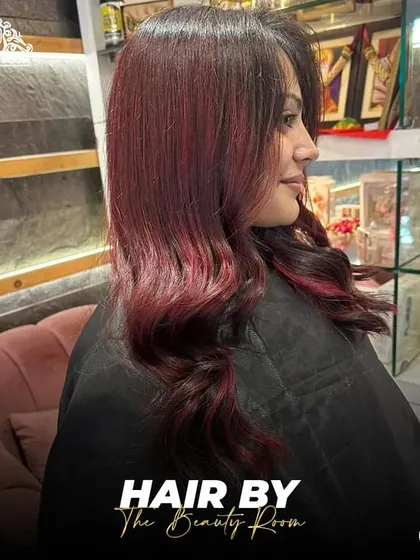 A beautiful example of a red balayage, where the color melts from a darker root to vibrant red ends. This technique ensures a graceful grow-out.