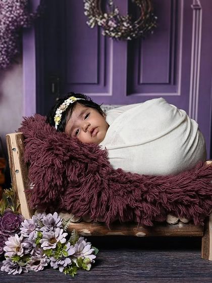 A beautiful, elaborate floral setup featuring a lavender-themed backdrop with a purple door and wisteria. This shows the level of detail and artistry I put into creating a completely unique and immersive set for your baby's photoshoot.