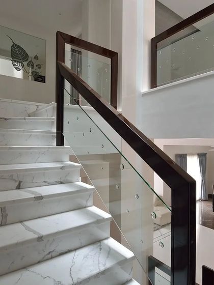 Views of different staircase designs, one with a multi-level view and another with classic marble steps and a wood-and-glass railing.