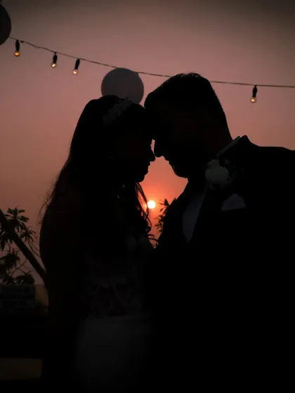 As the sun sets, I love to create timeless silhouettes that tell a story of romance. This moment from a Christian wedding in Mumbai captures the promise of a shared future against a beautiful, warm sky.