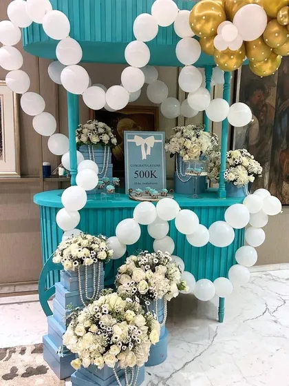 To celebrate a 500k milestone, we designed a surprise "Breakfast at Tiffany's" themed party, using the iconic Tiffany blue, white florals, pearls, and a custom dessert cart.