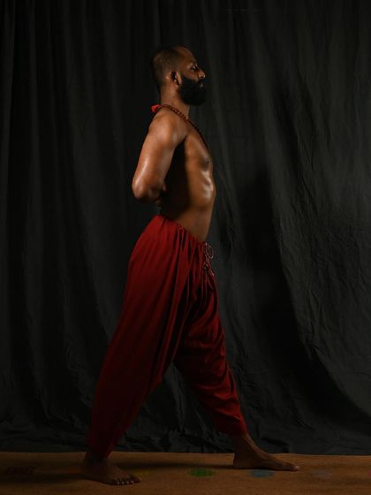 The standing posture for Parsvottanasana (Pyramid Pose), with hands in Paschima Namaskarasana (Reverse Prayer). This pose strengthens the legs and improves posture while preparing the body for the deep forward fold.