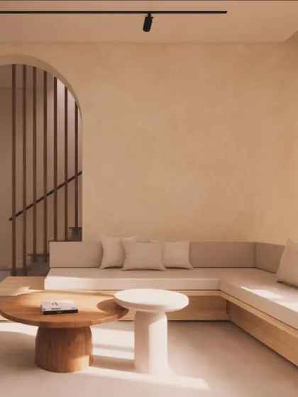 An example of my Japandi design style, this living area uses a neutral color palette, built-in low seating, and natural wood furniture. The arched entryway and lime-washed walls create a calm, minimalist, and tranquil atmosphere.
