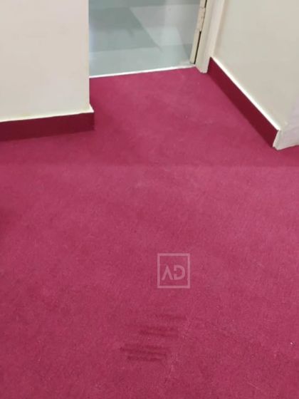 A wall-to-wall magenta carpet installation. This type of carpeting is great for bedrooms or prayer halls, providing sound dampening and a uniform, clean look.