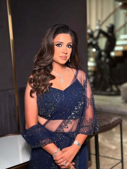 A close-up of the navy blue cocktail look. The smoky eye is blended to perfection, and the skin has a beautiful, luminous quality that looks sophisticated and modern.