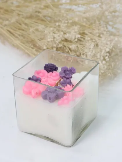 A simple yet elegant square glass candle adorned with pink and purple flower wax melts. It's a beautiful and thoughtful gift to celebrate the women who light up our lives.