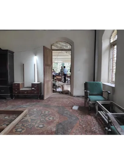 Another view of an interior space in its initial state of disarray. We carefully catalog inherited furniture pieces, planning for their repair and integration into the new design, ensuring continuity with the building's past.