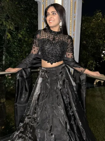 Another view of the black lehenga gown, showing how it looks in an outdoor, evening setting. It's a perfect choice for a cocktail party or reception.